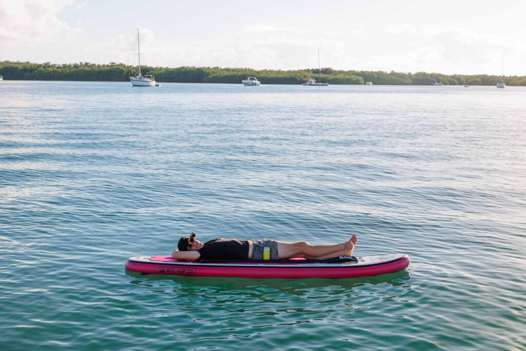 Elliot laying down on a SUP; Florida Keys Kayaking