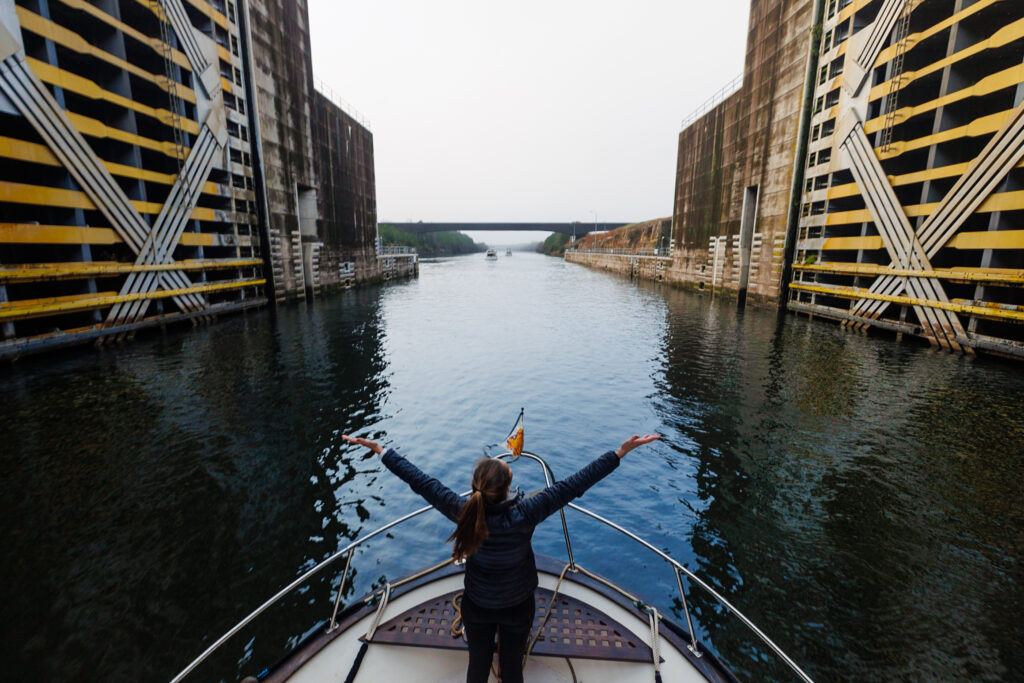 Jen on the front of our boat PIVOT celebrating a successful lock through, how to lock a boat