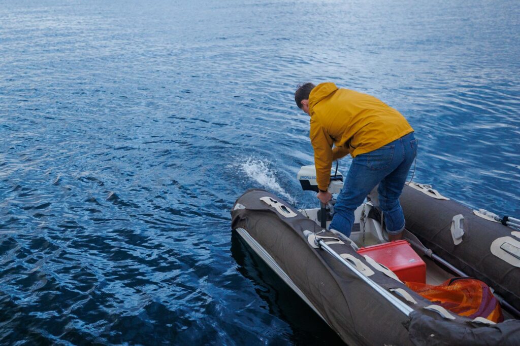 Elliott using the Manual Bilge Pump, one of the dinghy essentials