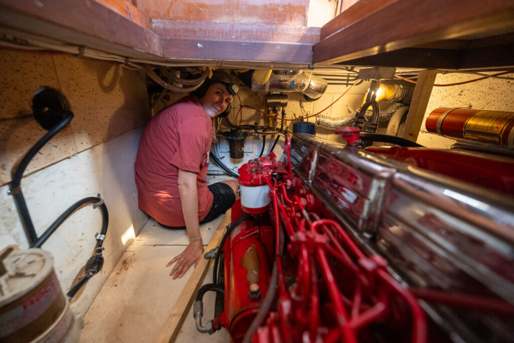 Jennifer in engine compartment as we work on boat project