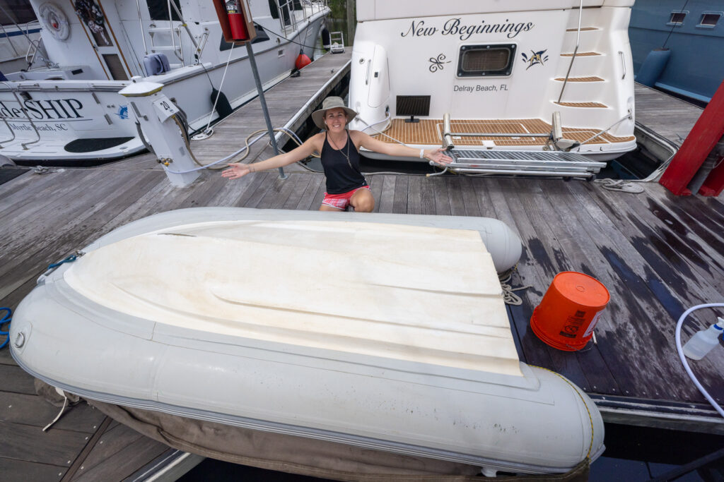 Jenn with the dinghy after cleaning it, an important part of boat maintenance