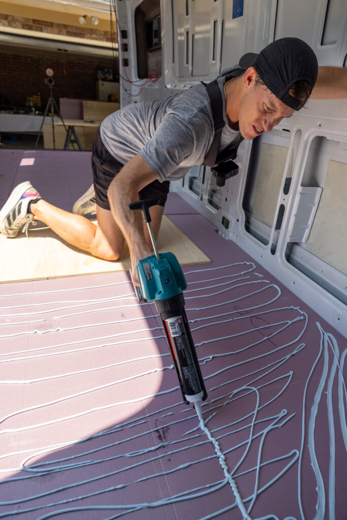 elliot laying out adhesive pl 300 with caulk gun