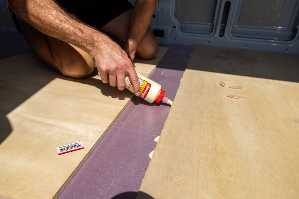 elliot applying wood glue to seam of wood