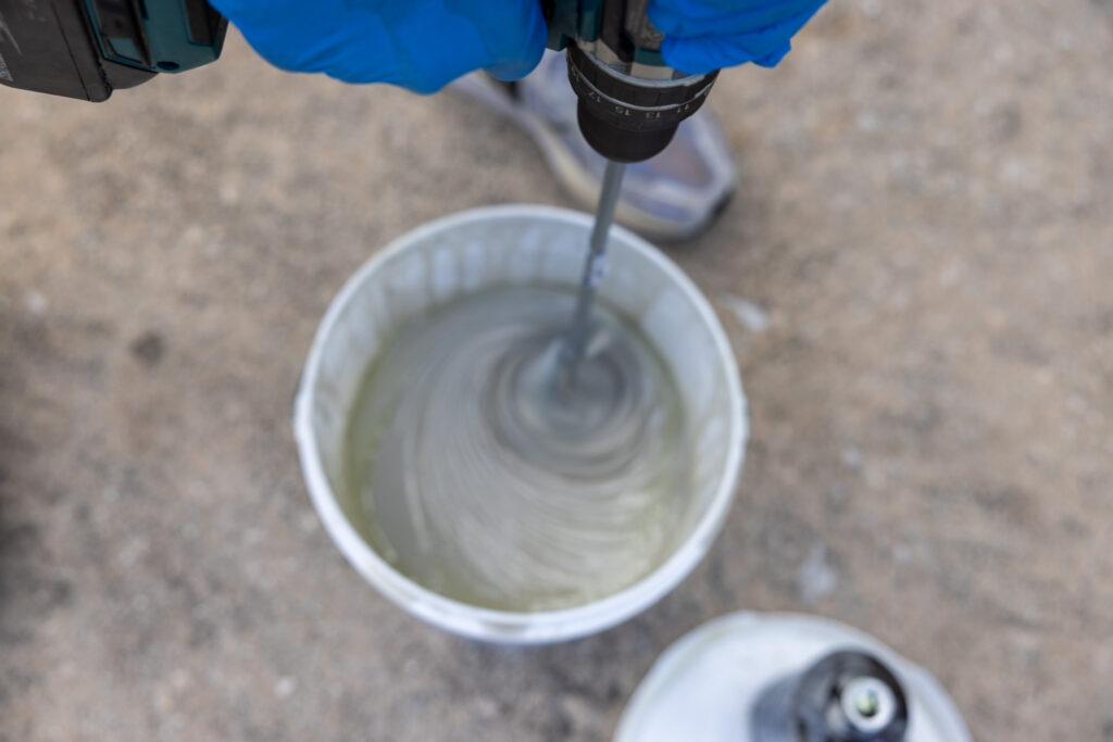 elliot mixing the two part epoxy with a drill mixer