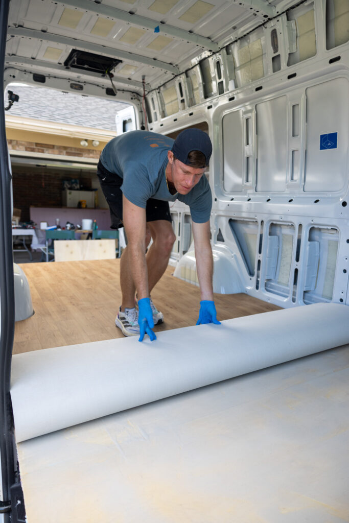 elliot rolling out the camper van floor forwrad covering the first part of the epoxy